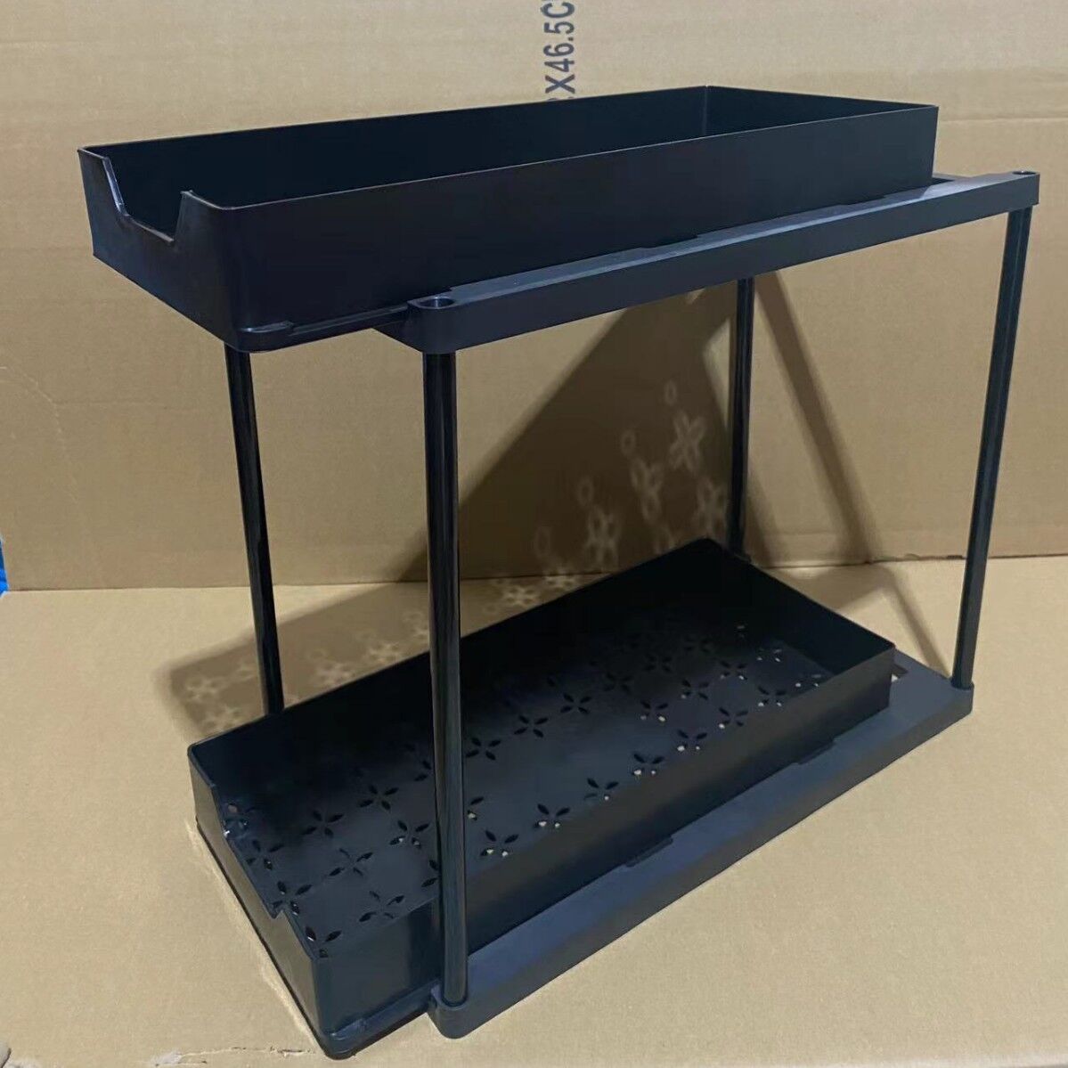 Two-tier pull-out storage rack. An organizational lifesaver for under the kitchen sink. Features adjustable shelves for easy storage of bottles and jars. In a sleek, modern design. Perfect as a kitchen shelf, bathroom organizer, or household storage solut