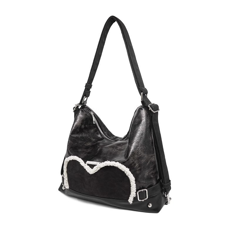 Stylish black tote backpack with heart embellishment - can be worn on one shoulder or as a backpack